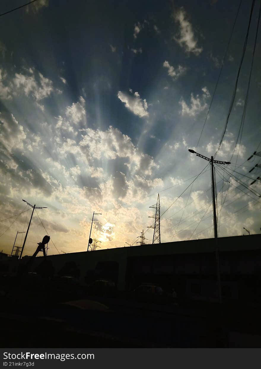 rays of sun penetrating the fluffy white clouds, scattering light in straight lines