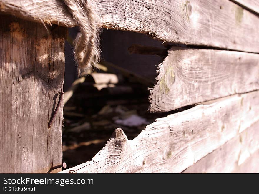 a hole in the wooden fencr