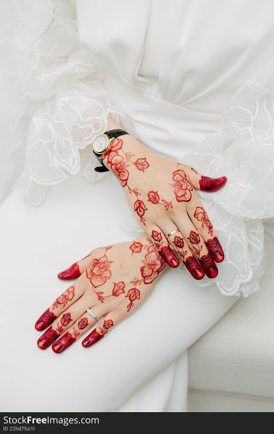 Close-up of a bride s hands decorated with intricate red floral henna