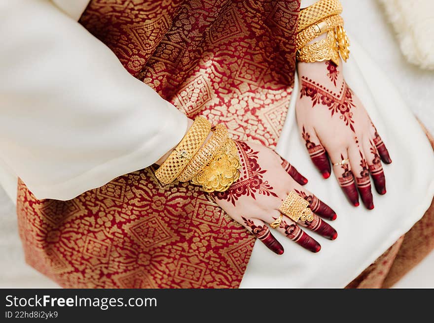 Close-up of a Malay bride s hands adorned with intricate red henna patterns