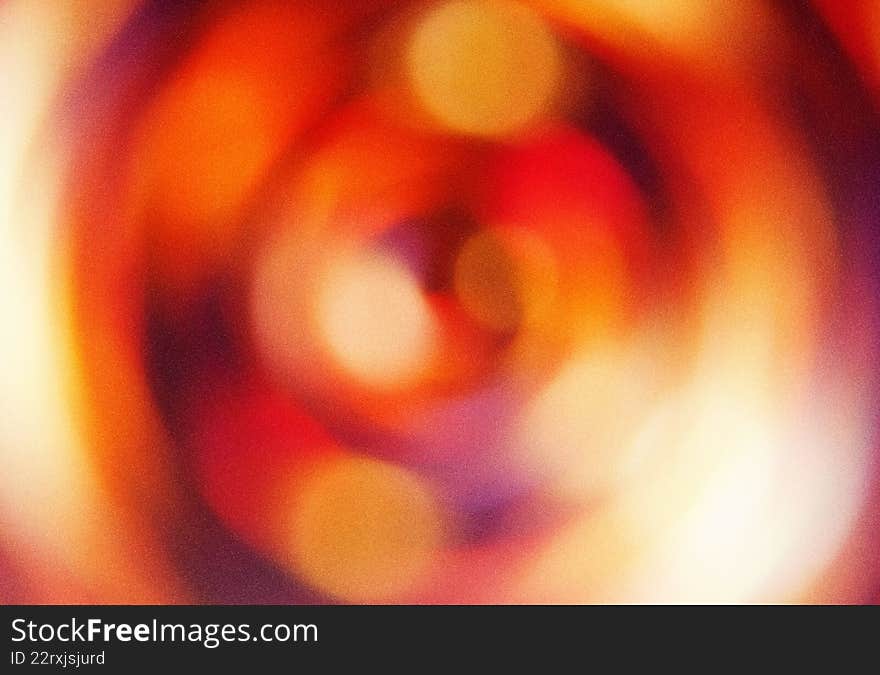 Blurred abstract pattern with circular designs in shades of orange and purple. Artistic radial gradient backdrop with soft textures. Round shapes create a dynamic background for projects. Use for texture design, background illustration, and color concepts