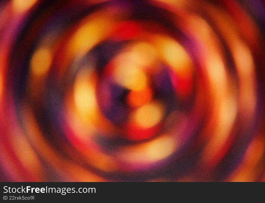 Blurred abstract background with circular patterns in shades of orange and purple. Artistic radial gradient backdrop with soft textures. Round shapes create dynamic backdrop for projects. Use for texture design, background illustration, color concepts