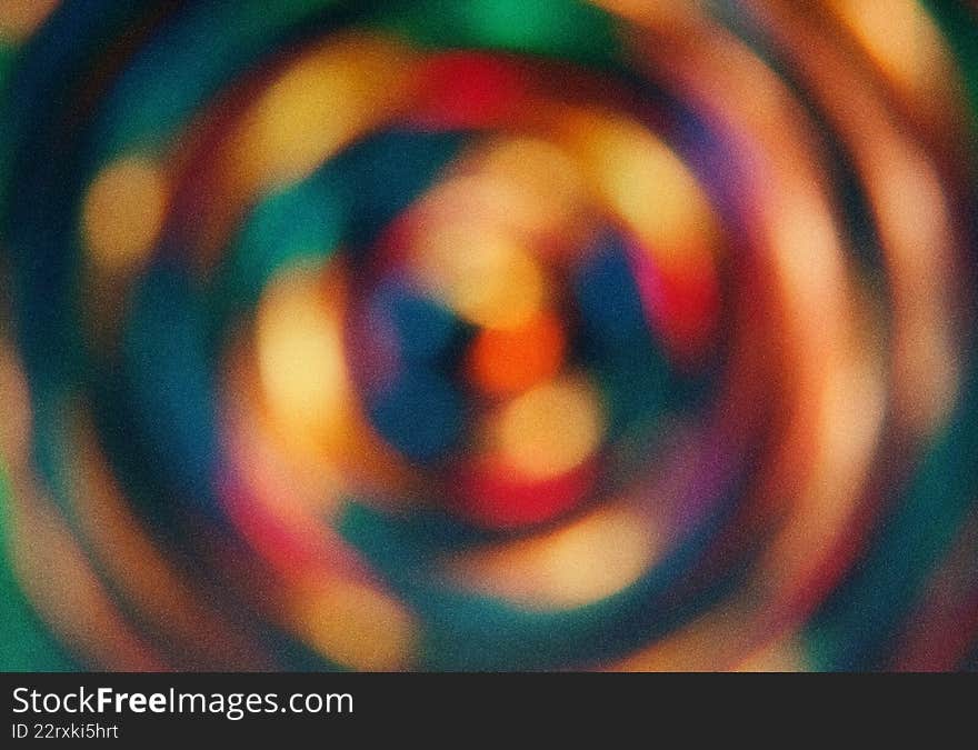 Blurred circular patterns in shades of green, blue, orange, and red. Artistic radial gradient backdrop with soft textures. Round shapes create a dynamic background for projects. Use for texture design, background illustration, and color concepts