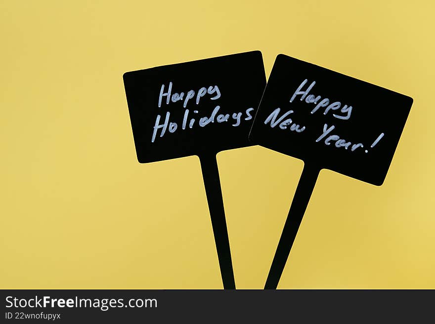 Happy Holidays and Happy New Year signs in yellow background