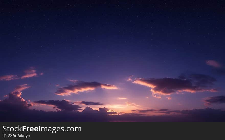 Starry night sky with colorful clouds at twilight