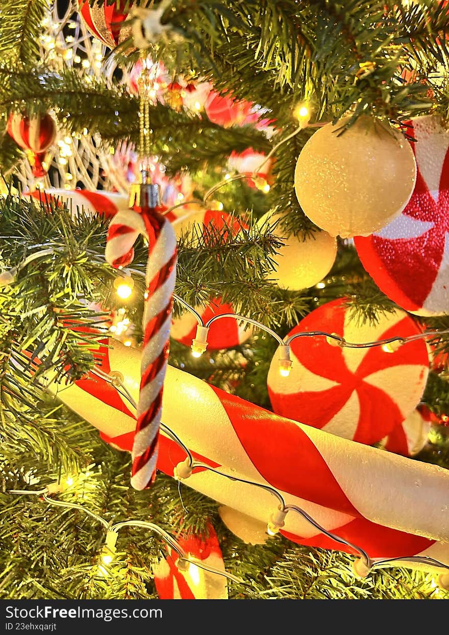 Colorful Christmas tree decorations with candy cane, ribbon, and ornaments, creating a joyful and traditional holiday scene.