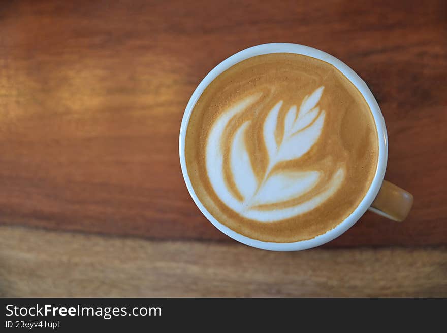 Top view of latte art coffee on wooden table for drinking in morning