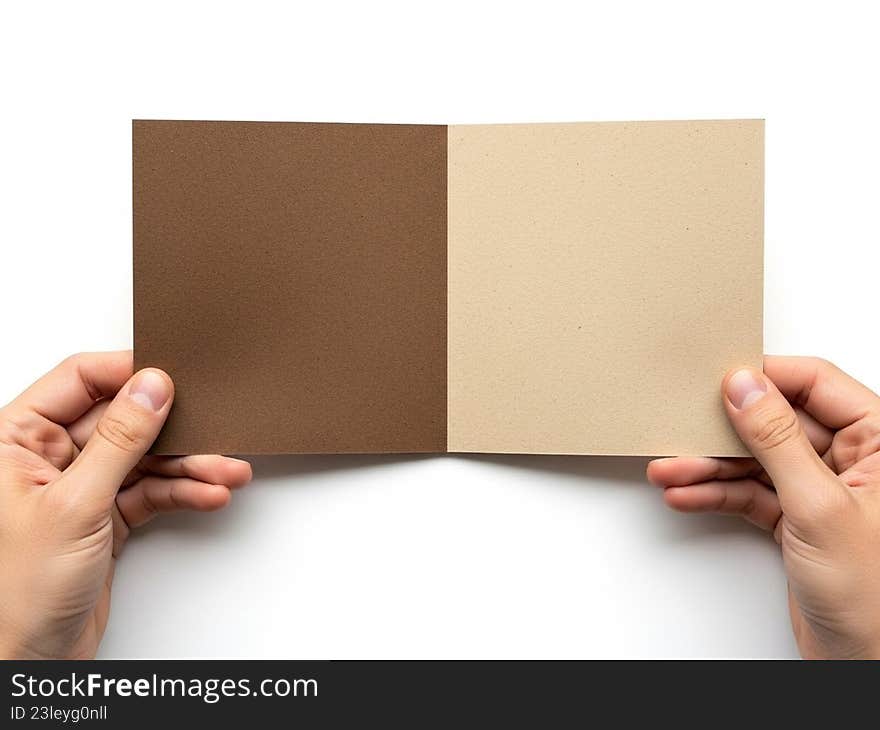The image shows a pair of hands holding two pieces of cardboard. The cardboard pieces are of different shades, one being a darker brown and the other a lighter beige. The hands are positioned in such a way that the two pieces are side by side, allowing for a clear comparison of their color differences. The image shows a pair of hands holding two pieces of cardboard. The cardboard pieces are of different shades, one being a darker brown and the other a lighter beige. The hands are positioned in such a way that the two pieces are side by side, allowing for a clear comparison of their color differences