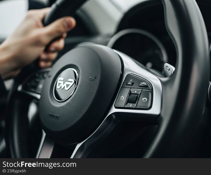 Driver s hand on steering wheel with controls