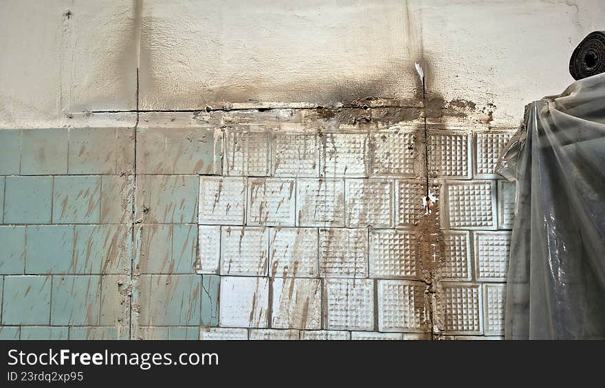 Old tiled wall with dirty, cracked surface and peeling paint. Grimy texture representing decay and demolition. Old tiled wall with dirty, cracked surface and peeling paint. Grimy texture representing decay and demolition