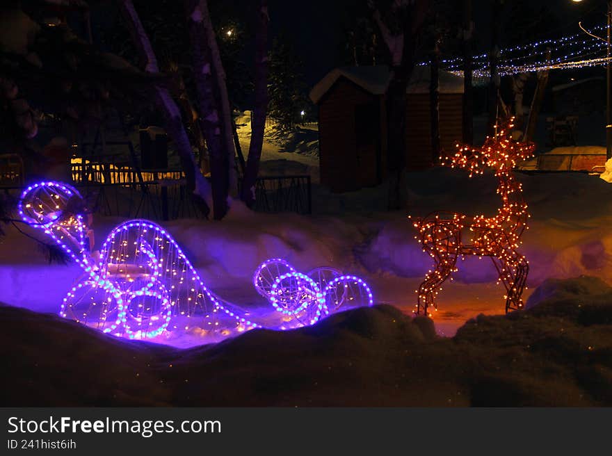 festive installation in the form of Santa's reindeer carrying a Christmas sleigh, surrounded by magical sparkling lights of garlands