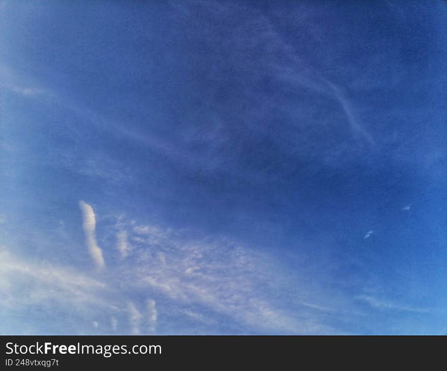 The image is of a blue sky with cirrus clouds