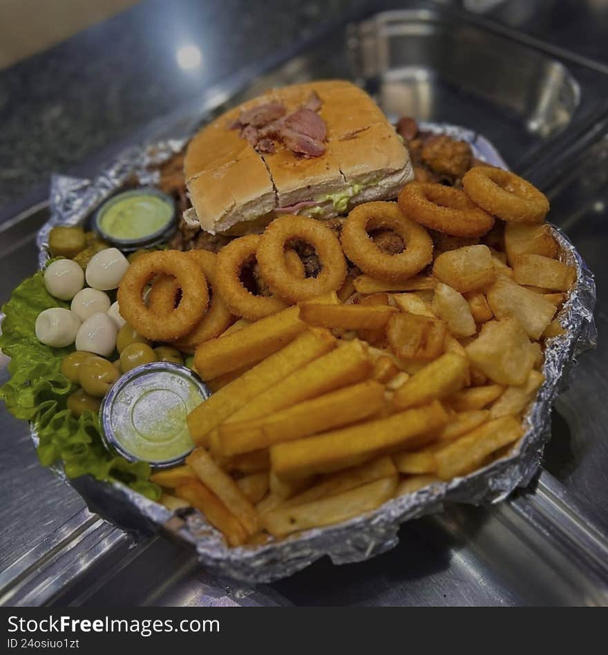 Delicious portion of french fries with onion rings and fried chicken ready to eat