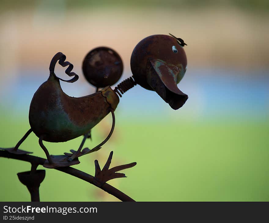 Rustic metal duck sculpture stands outdoors, crafted from recycled materials for garden decor
