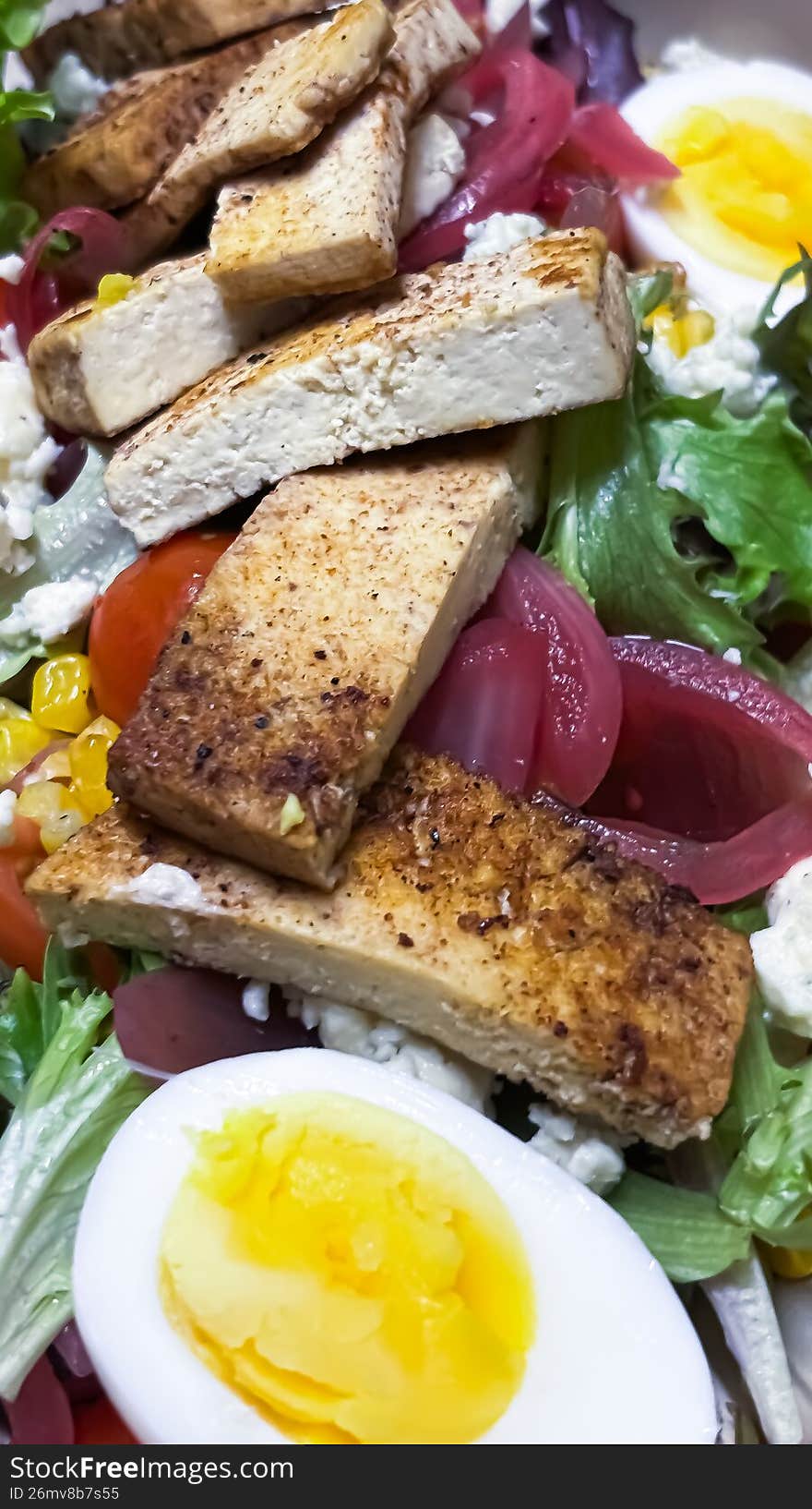 A plant-forward reimagining of a classic. This shot features smoky, cross-hatched grilled tofu arranged in clean rows alongside creamy avocado, crisp radishes, sweet corn, and vine-ripened tomatoes. It�s a colorful, nutrient-dense contrast to the white winter landscape of the Ottawa Valley.