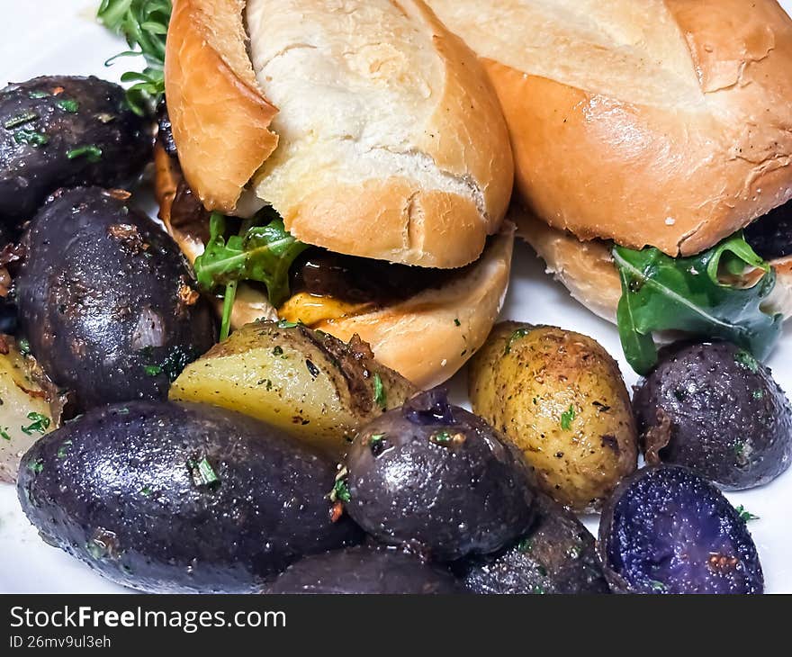 A sophisticated twist on a lunch favorite. This shot features a triple-decker turkey club with crisp bacon and vine-ripened tomatoes, served alongside a side of roasted, sea-salted purple potatoes. The rich, earthy violets of the potatoes add an unexpected and artistic splash of color to this hearty winter meal.