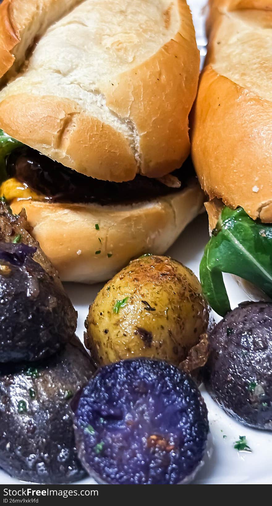 A sophisticated twist on a lunch favorite. This shot features a triple-decker turkey club with crisp bacon and vine-ripened tomatoes, served alongside a side of roasted, sea-salted purple potatoes. The rich, earthy violets of the potatoes add an unexpected and artistic splash of color to this hearty winter meal.